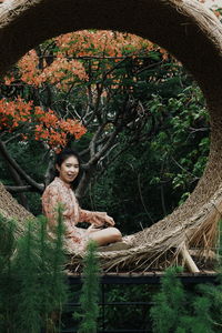 Portrait of woman sitting on tree