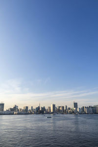 View of the tokyo skyline from odaiba during the day.