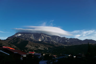 Scenic view of mountains against blue sky