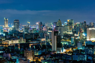 Illuminated buildings in city against sky