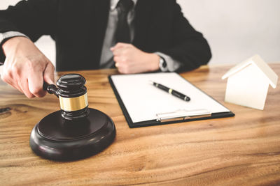 Midsection of man using mobile phone on table