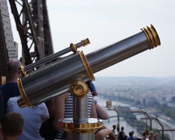 Close-up of coin-operated binoculars against cityscape