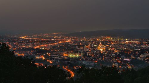 High angle view of illuminated city against sky at night