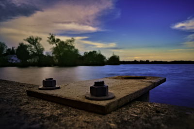 Boat on lake against sky at sunset