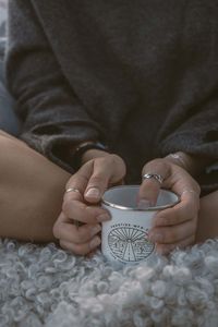 Midsection of man holding coffee cup