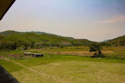 Scenic view of field and mountains against clear sky