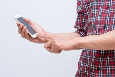 Midsection of man using mobile phone against white background