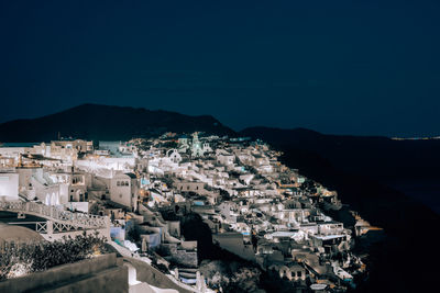 High angle view of buildings in city against clear blue sky