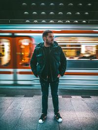 Full length of young man standing against train