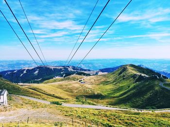 Overhead cable car over mountains against sky