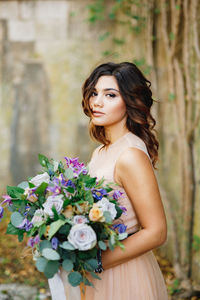 Portrait of a beautiful young woman holding flower bouquet