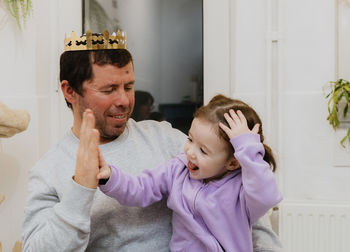 A young man with a crown plays with his daughter after eating a royal galette.