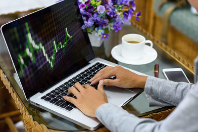 Midsection of man using laptop on table