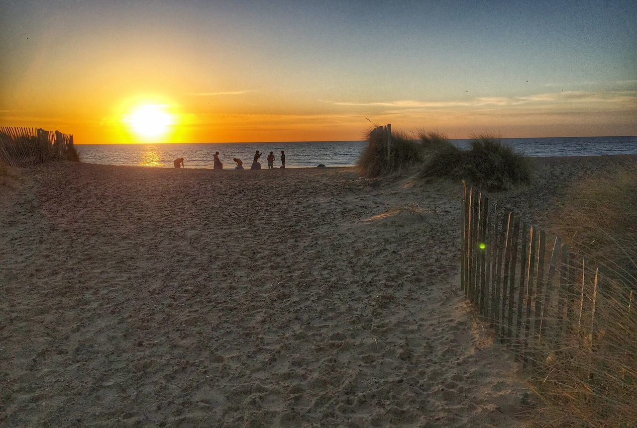 sunset, sea, beach, sun, horizon over water, tranquil scene, scenics, tranquility, water, beauty in nature, shore, sky, orange color, sand, nature, sunlight, idyllic, remote, incidental people, outdoors