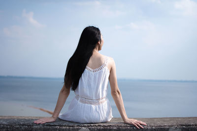 Rear view of woman looking at sea against sky