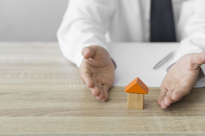 Close-up of man holding hands on table