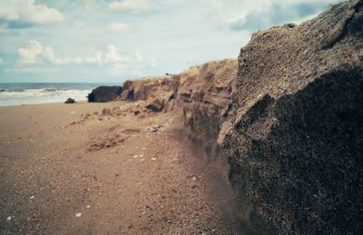 Scenic view of rocks on beach against sky