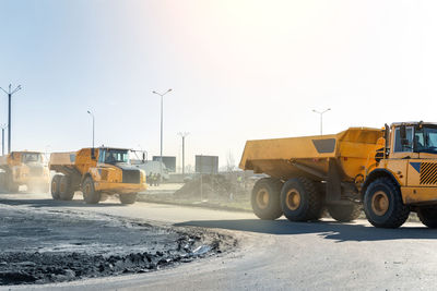 Vehicles on road against clear sky during winter