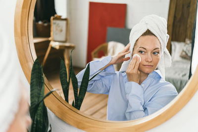 Portrait of smiling young woman in mirror