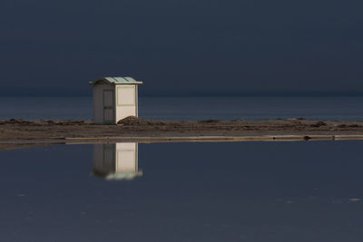 Lighthouse by sea against sky