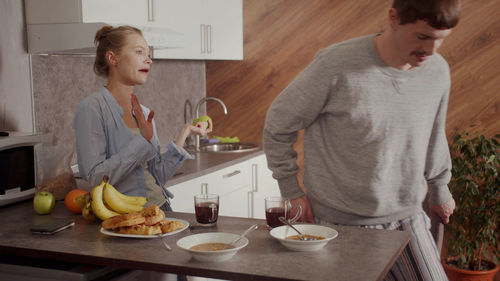 Wife talking with husband in kitchen