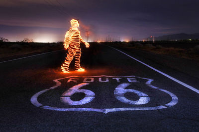 Light painting on road against sky at night