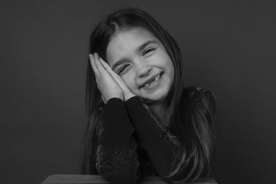 Portrait of smiling woman against gray background