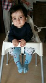 Portrait of cute boy sitting on bench