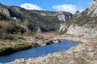 Scenic view of river amidst mountains against sky