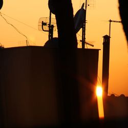 Silhouette man working against sky during sunset