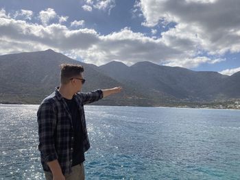 Man standing by sea against sky