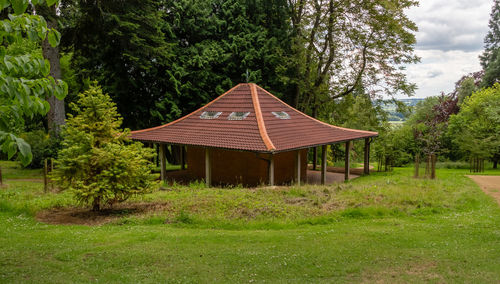 Gazebo on field against trees in forest