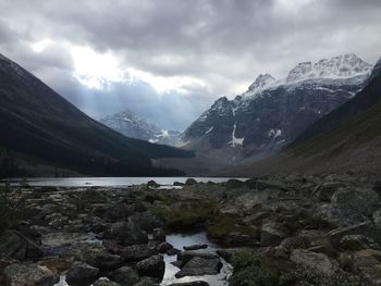 Scenic view of mountains and lake against cloudy sky