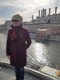 Woman standing on railing against canal