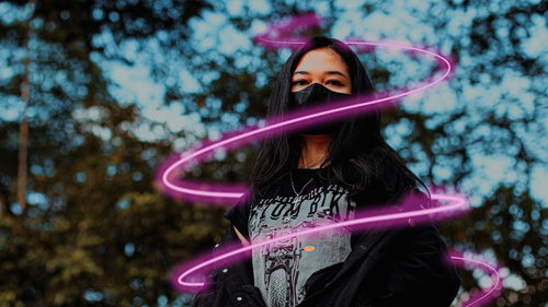 Portrait of woman standing against pink tree