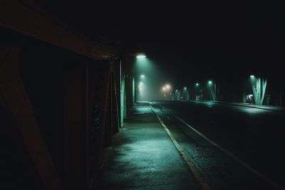 Empty illuminated railroad tracks in city at night