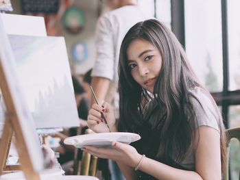 Portrait of young woman sitting on table