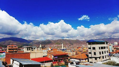 Houses in town against cloudy sky