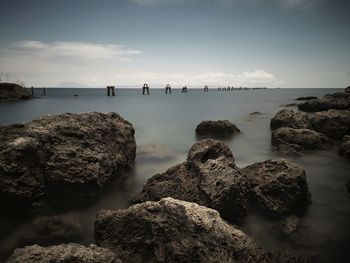 Panoramic view of rocks on beach against sky