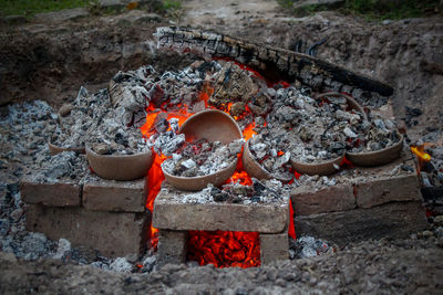 Various ceramic vessels on the fathoms of a campfire