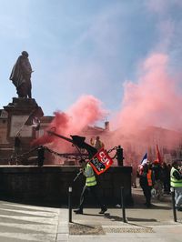 People in traditional clothing against sky in city