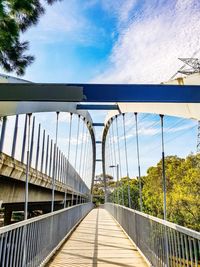 Footbridge over footpath against sky