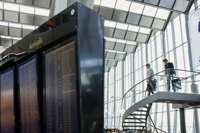 Low angle view of business colleagues moving down steps in airport