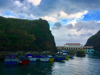 Boats moored in water against sky