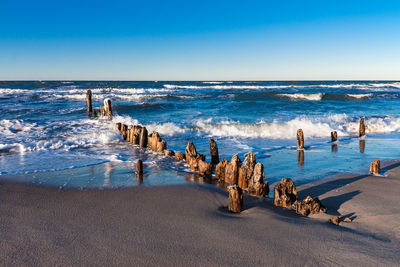 Scenic view of beach against clear blue sky