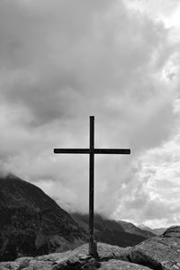 Religious cross on mountain against sky