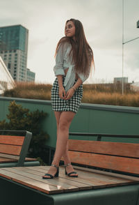 Young woman standing outdoors against sky