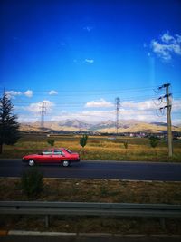 Cars on road against blue sky