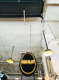 Low angle view of illuminated lighting equipment on street against building