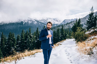 Man standing on snowcapped mountain during winter